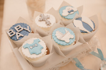 Cupcakes for the birthday party of an infant, christening of the baby boy, white chocolate with blue powder