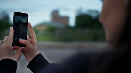 Girl taking selfie photo on cellphone at street. Woman hands using mobile phone