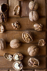 Walnut with the opening of the shell. Walnuts and hazelnuts lie on the wooden surface