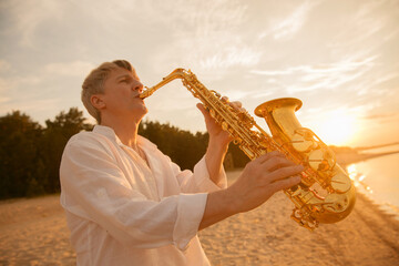 The musician plays the saxophone on a Golden sunset 