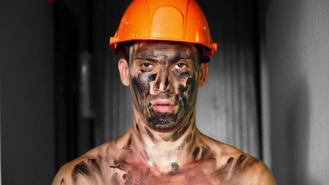 Portrait Dirty Tired after work Building Worker in the sunlight. Handsome Caucasian Serious Man in a Hard Hat. Filthy Job and Physical labor. People Working Equipment. Close up