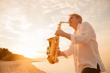 The musician plays the saxophone on a Golden sunset 