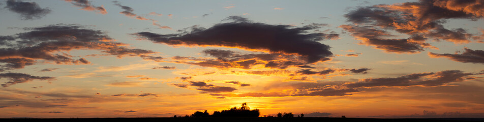 The evening sunset. Panorama. Purple clouds. Tragic gloomy sky.