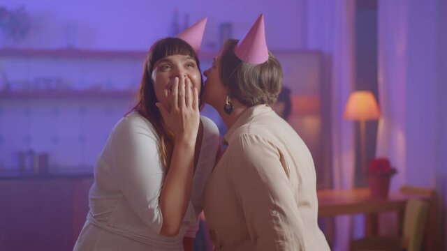 Two charming stylish oversize young women gossiping at birthday party