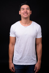 Young handsome multi ethnic man against black background