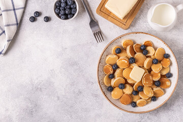 Trendy breakfast with mini pancakes and blueberries.