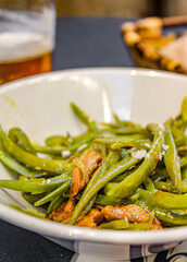 Green beans and mushrooms in a small bowl as a pintxo or tapa in a bar in Spain. Vegetarian healthy tapa with vegetables served at the old town in San Sebastian. 