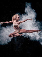 Obraz na płótnie Canvas dancing girl in flour (powder). Black studio. Ballet dance.