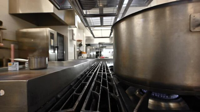 Professiona chef preparing and cooking food in a commercial kitchen. Zoom in, Dolly shot camera movement. High quality 4k footage.