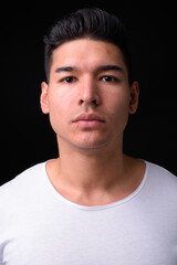 Young handsome multi ethnic man against black background