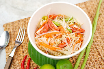 Top view and Close up papaya salad or ''Som tum Thai '' popular Thai food, mat decorating with ingredients background.