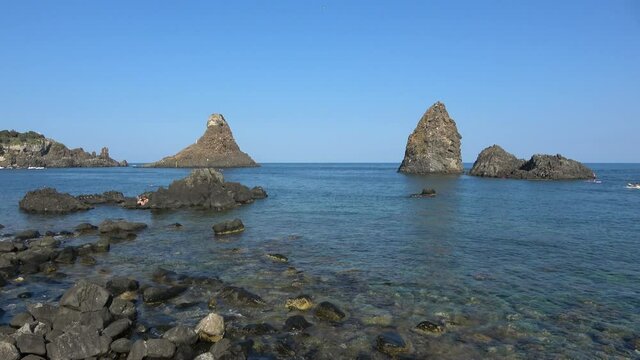View of the Faraglioni of Acitrezza. Rocks of the Cyclops, typical lava stacks. Sicily, Italy. Footage 4k