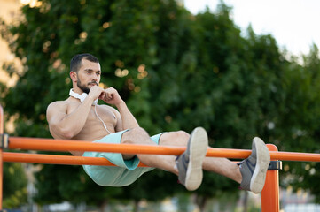 A person trains the abs on parallel bars on the street