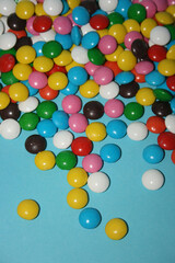 multicolored delicious candies with chocolate on a blue background