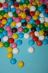 multicolored delicious candies with chocolate on a blue background