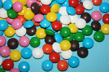 multicolored delicious candies with chocolate on a blue background