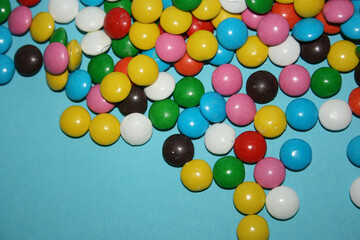 multicolored delicious candies with chocolate on a blue background