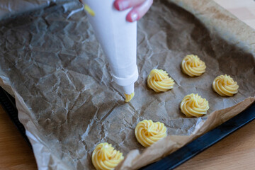 Bignè alla panna all'italiana. Profiteroles al cioccolato fondente. Preparazione a mano prima della cottura al forno.