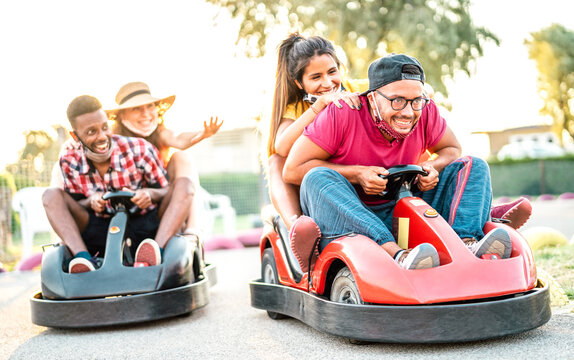 Milenial Friends Having Fun At Children Playground On Go Kart Race - Young People With Face Mask Competing On Mini Car Racing - New Normal Lifestyle Concept With Focus On Right Guy - Backlight Filter