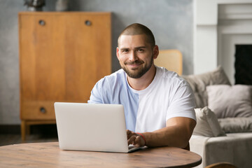 a handsome man with a beard at a laptop, communicating with loved ones