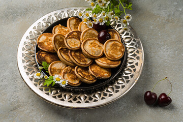 Dutch mini pancakes called poffertjes for breakfast, with a hot cup of tea. Horizontal orientation