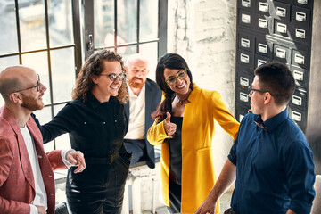 Beautiful business people are using gadgets, talking and smiling during the conference in office