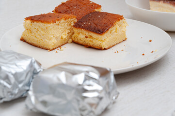 Traditional Brazilian dessert (known as Bolo Gelado) - Making step by step: Cake pieces wrapped and not wrapped in aluminum foil. Selective focus.