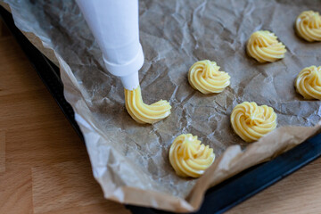 Bignè alla panna all'italiana. Profiteroles al cioccolato fondente. Preparazione a mano prima della cottura al forno.