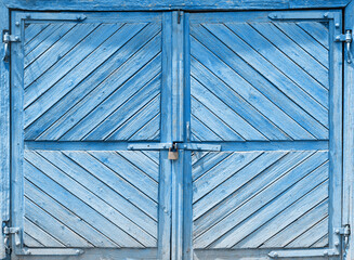 Old blue shed door with a closed rusty lock.