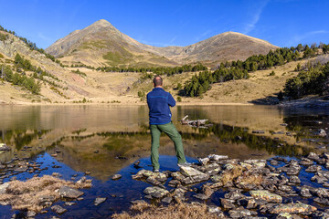 Hiker enjoying beautiful view at the lake (The Peak of Peric reflections, Capcir, France)