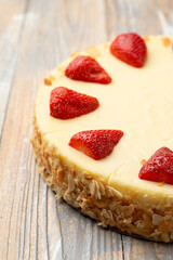 Classic cheesecake with strawberries on top and almond flakes on the border, close up, delicious advertisement photo