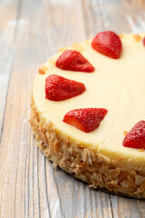 Classic cheesecake with strawberries on top and almond flakes on the border, close up, delicious advertisement photo