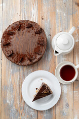 Top view of a birthday tea party with chocolate cake and black tea on wooden table