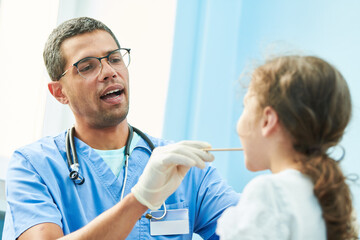 ENT medical examination of little girl by african doctor