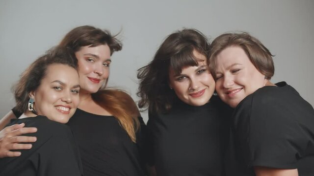 Close up of beautiful plus size young women posing on grey background.