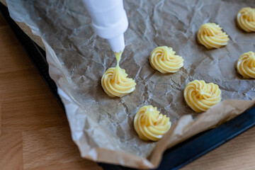 Bignè alla panna all'italiana. Profiteroles al cioccolato fondente. Preparazione a mano prima della cottura al forno.
