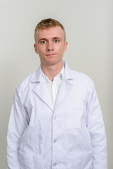 Portrait of young man doctor with blond hair