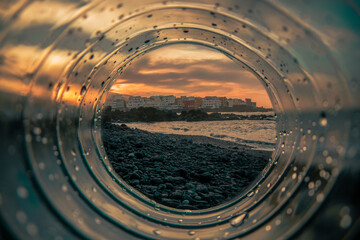 Plastic, transparent tunnel through which you can see the beach at sunset