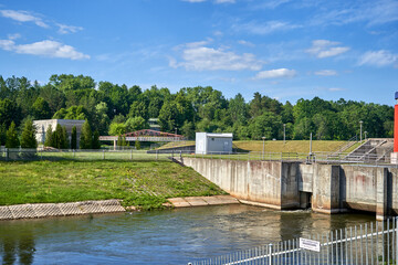 Fototapeta premium Small dam on the river with fence around it 