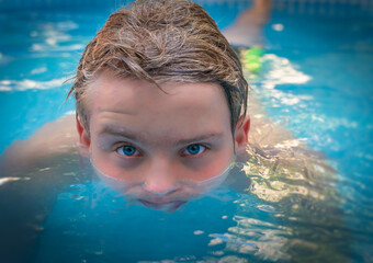yong man with amazing blue eyes in swimming pool ,enjoying his holiday .