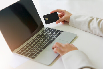 Woman holding credit card for online shopping on computer laptop.