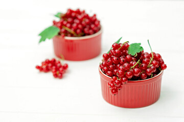Red currant berries in a cocotte on a white background. Natural vitamins concept.