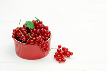 Red currant berries in a cocotte on a white background. Natural vitamins concept.