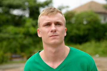 Portrait of young man with blond hair outdoors