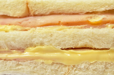 close up of sandwich stuffed ham and cheese on white background