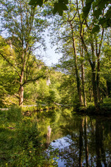 Fototapeta na wymiar Dove Dale - beautiful view over the water among the green trees on a sunny day