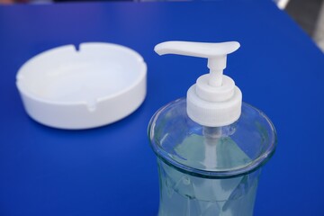 Jabón gel hidroalcoholico y cenicero en terraza en un bar