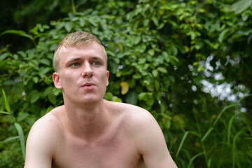 Portrait of young man with blond hair shirtless outdoors