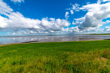 View of the Lower Saxony Wadden Sea at low tide in summer with blue sky and beautiful clouds