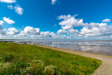 View of the Lower Saxony Wadden Sea at low tide in summer with blue sky and beautiful clouds